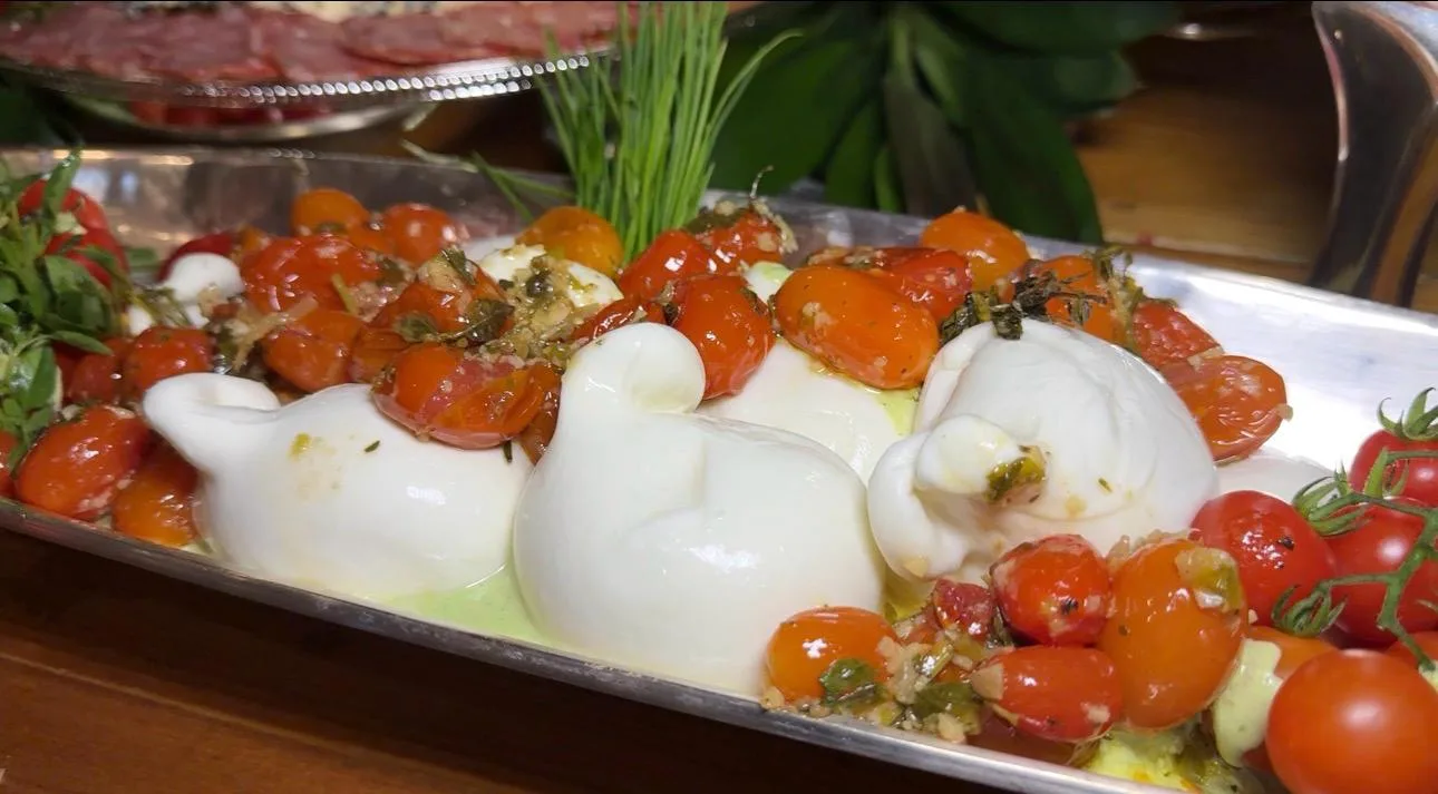 Burrata com tomates e folhas na apresentação gastronômica