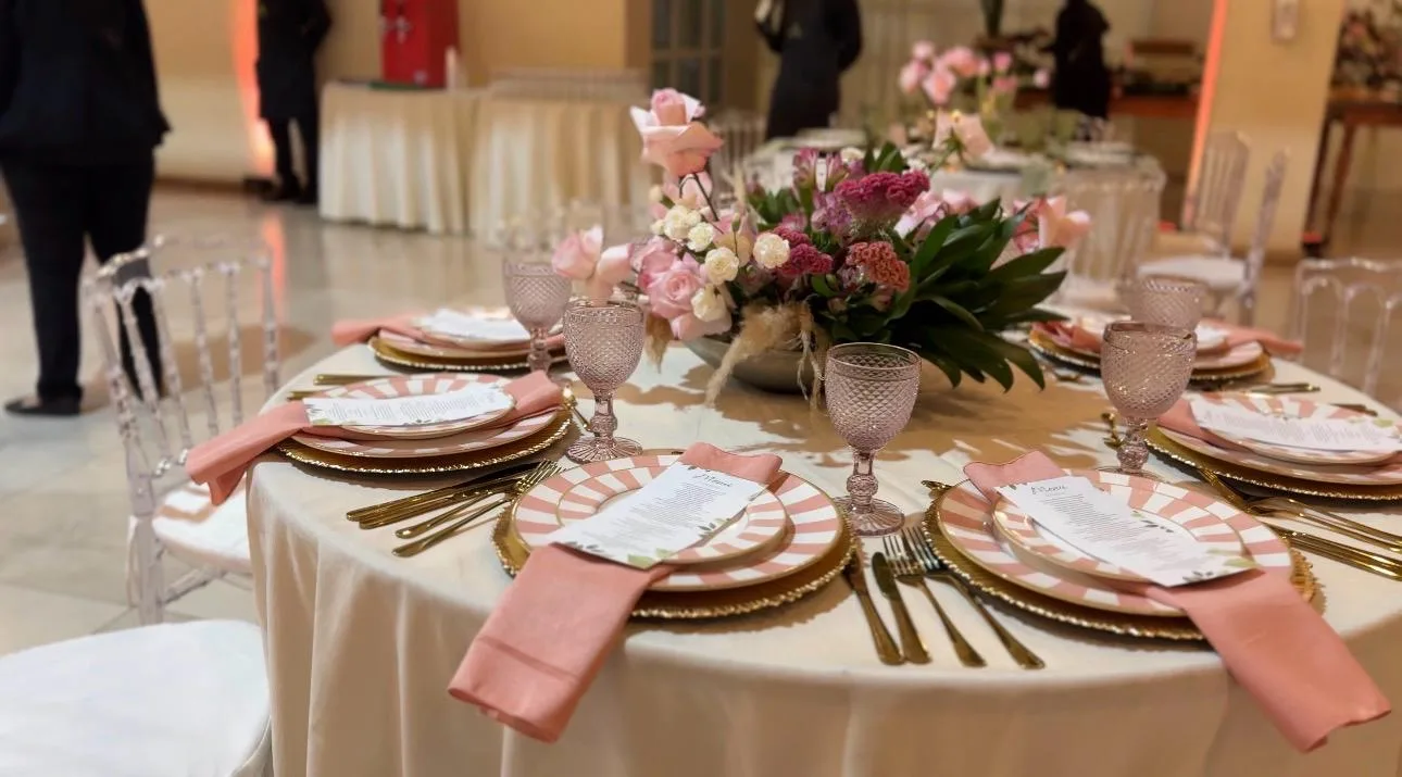 Mesa posta com flores e guardanapos em tons rosados